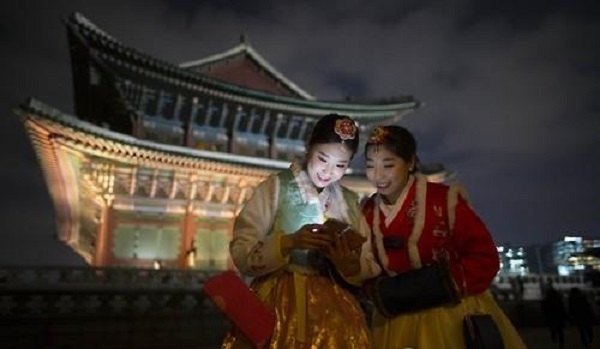 Two tourists in the Korean traditional dress hanbok join in a night tour program in Gyeongbok Palace in March, 2016. (Yonhap)