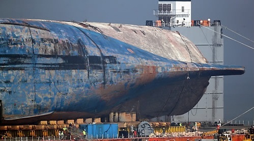 Operators work to drain water and mud from the Sewol ferry at the port of Mokpo on April 3, 2017. (Yonhap)