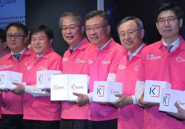 Participants pose for a photo at the opening ceremony of the internet-only K bank at KT Square in Gwanghwamun, central Seoul, Monday. They include K bank CEO Shim Sung-hoon (third from right), Financial Services Commission Chairman Yim Jong-yong (fourth from right), KT Chairman Hwang Chang-kyu (second from right) and Woori Bank CEO Lee Kwang-goo (right). (Yonhap)