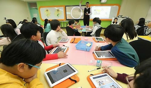 Students use tablets during class at an elementary school in Seoul. (Yonhap file photo)