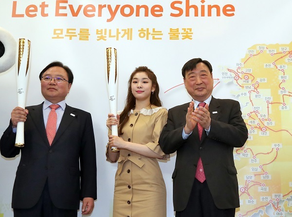 Kim Yu-na, former Olympic figure skating champion and honorary ambassador for the 2018 PyeongChang Winter Olympics, poses with the Olympic torch, flanked by Soohorang (left), the PyeongChang 2018 mascot, and Lee Hee-beom, head of PyeongChang's organizing committee, in Seoul on April 17, 2017. (Yonhap)
