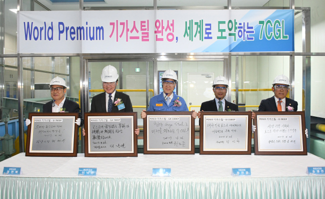 Posco Chairman Kwon Oh-joon (center) poses with a message of encouragement and his autograph on a giga steel plate during the completion ceremony of Posco’s No. 7 continuous galvanizing line facility in Gwangyang, South Jeolla Province, Wednesday. (Posco)