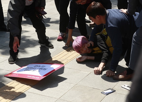 Police subdue pro-gay protestors who attempted to approach front-runner Moon Jae-in of the liberal Democratic Party of Korea as he arrived at Sejong Center for the Performing Art in central Seoul to attend a debate session, Thursday. (Yonhap)
