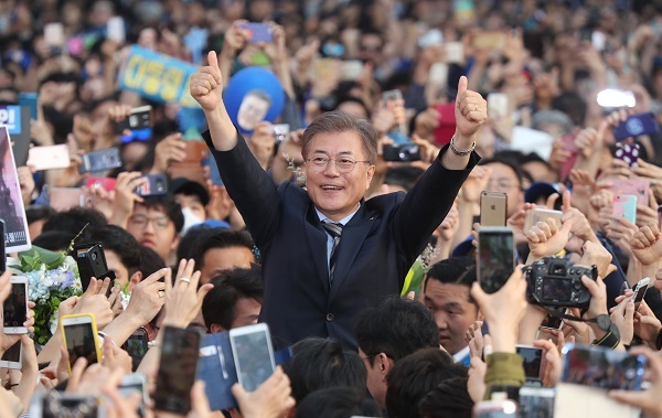 Moon Jae-in, the presidential candidate of the liberal Democratic Party, gives two thumbs up while surrounded by supporters and voters in the college district of Shinchon in northwestern Seoul on April 30, 2017. (Yonhap)