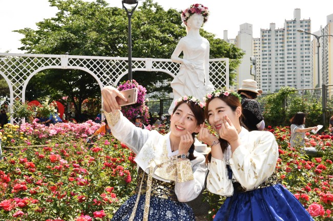 Visitors take a selfie at last year’s Seoul Rose Festival in Muk-dong, Jungnang-gu. (Seoul Rose Festival)