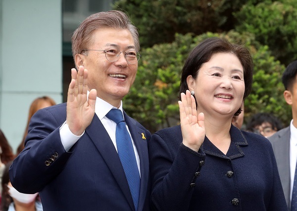 Moon Jae-in, the presidential candidate of the Democratic Party, and his wife Kim Jung-sook wave to photographers after voting at a polling station in Hongeun-dong, western Seoul, on May 9, 2017. (Yonhap)