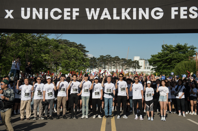 Artists from YG Entertainment pose with participants of the YG X UNICEF Walking Festival in Seoul on Sunday. (YG Entertainment)