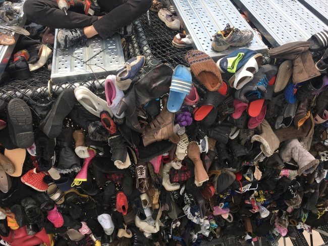 Workers hang worn-out shoes on Shoes Tree on Seoullo 7017, Seoul’s soon-to-open pedestrian-friendly park, near Seoul Station on Tuesday. (Kim Da-sol/The Korea Herald)