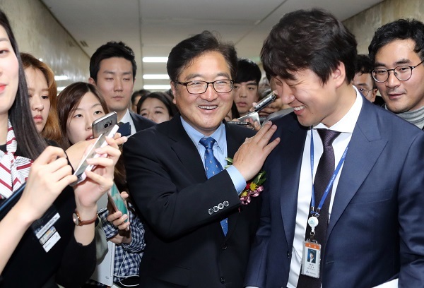 Newly elected Floor Leader Rep. Woo Won-shik (center) of the ruling Democratic Party of Korea is surrounded by journalists after a party meeting at the National Assembly in Seoul on Tuesday. (Yonhap)