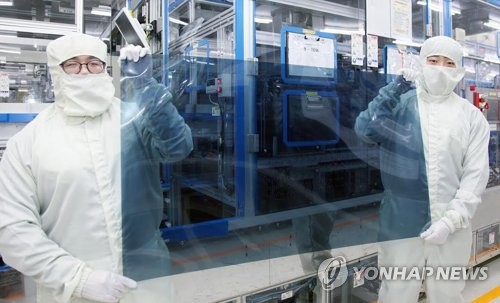 Two employees show an LCD Nano Cell panel manufactured by LG Display at a factory in Paju, Gyeonggi Province, in March. (Yonhap)