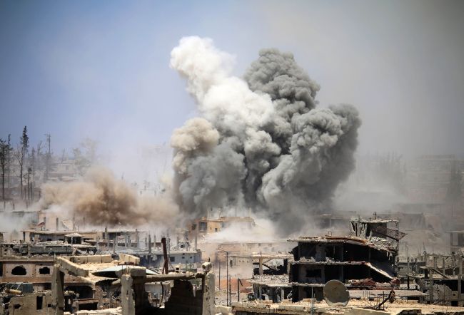 Smoke rises from buildings following a reported air strike on a rebel-held area in the southern Syrian city of Daraa, on May 22, 2017. (AFP-Yonhap)