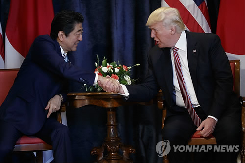 US President Donald Trump (right) shakes hands with his Japanese counterpart Shinzo Abe at a bilateral summit held in Taormina, Italy on Friday. (Yonhap)