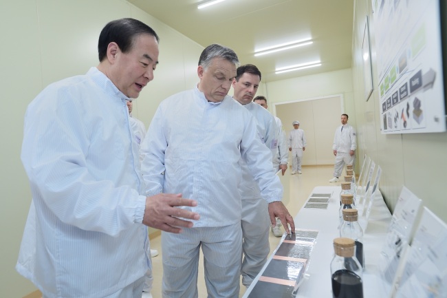 Samsung SDI President Jun Young-hyun (left) shows materials used to make lithium-ion batteries to Hungarian Prime Minister Viktor Orban (center) at the company’s new plant in Goed, Hungary, Monday.(Samsung SDI)