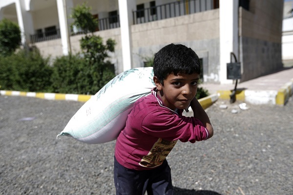 A Yemeni boy carries food aid distributed by a local charity during the Muslim holy fasting month of Ramadan, in the capital Sanaa, on May 29, 2017. (AFP-Yonhap)