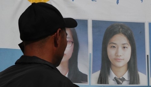 In this photo taken on May 19, 2017, the father of Sewol ferry victim Heo Da-yoon talks on the phone in front of his daughter`s photo in Mokpo, some 410 kilometers south of Seoul. (Yonhap)