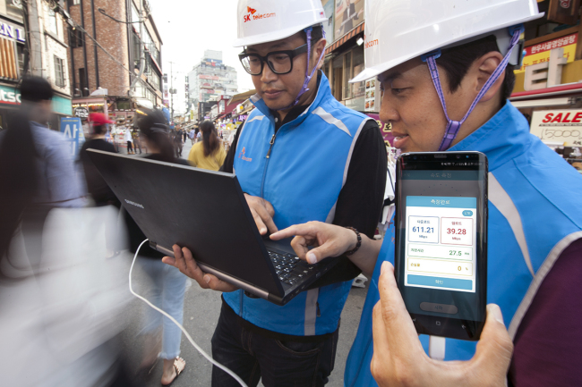 SK Telecom employees test the data transfer speed of the 4.5G network in a neighborhood nearby Hongik University in Seoul. (SK Telecom)