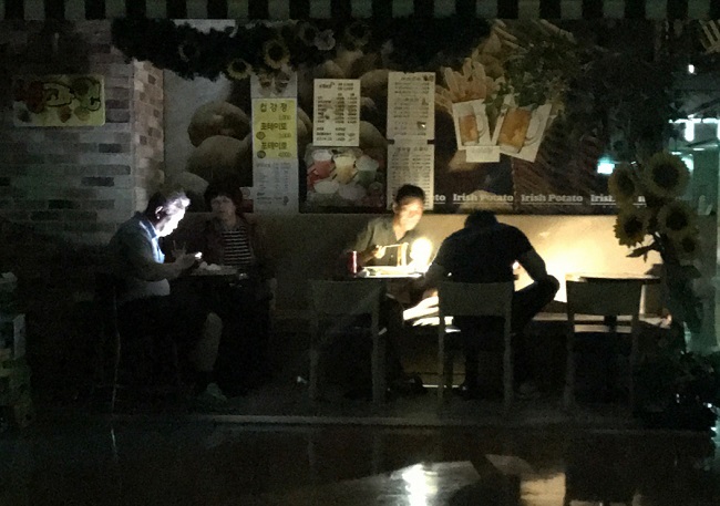 Diners at a restaurant eat in the dark after a power failure at Techno Mart in southwestern Seoul on Sunday. (Yonhap)