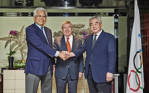 Chang Ung, then president of the International Taekwondo Federation (left) shakes hands with WTF President Choue Chung-won (right), with International Olympic Committee President Thomas Bach in the middle, in Nanjing, China, on the sidelines of the Youth Olympic Games in Nanjing, China. Chang and Chung signed 