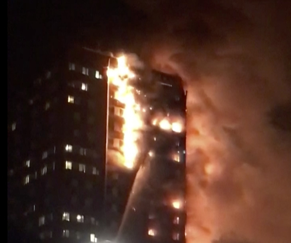 A building is on fire in London, Wednesday, June 14, 2017. Firefighters are battling a massive fire in an apartment high-rise in London. One side of the building appeared to be in flames. (AP-Yonhap)