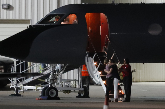 Two people hug outside the plane carrying Otto Warmbier, a 22-year-old University of Virginia undergraduate student who was imprisoned in North Korea in March 2016, before he is transferred from a transport aircraft to an ambulance at Lunken regional airport, Tuesday, June 13, 2017. (AP-Yonhap)