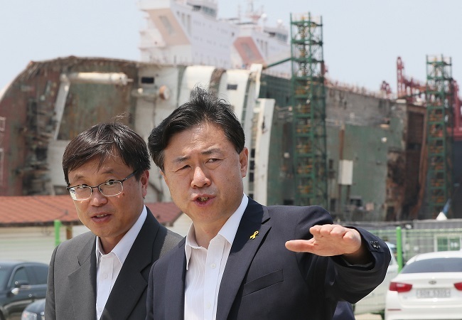 Oceans and Fisheries Minister Kim Young-choon (right) talks to an official during a visit to the dock where the salvaged Sewol ferry is placed in Mokpo, southwest of Seoul, on June 17, 2017 (Yonhap)