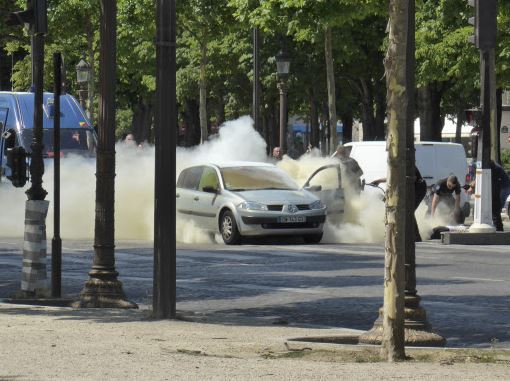 In this photo provided by Noemie Pfister, French gendarmes use fire extinguishers after a man rammed into a police convoy and detonated an explosive device on the Champs Elysees avenue in Paris, France, Monday, June 19, 2017. (AP-Yonhap)