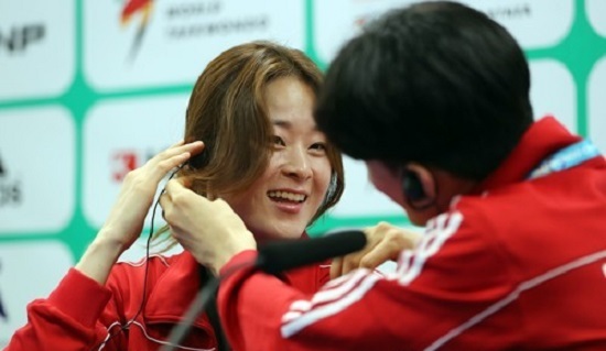 South Korean taekwondo practitioner Oh Hye-ri (left) puts on an earpiece with some help from fellow athlete Lee Dae-hoon before a press conference at the World Taekwondo Federation World Taekwondo Championships at T1 Arena in Muju, North Jeolla Province, on June 24, 2017. (Yonhap)
