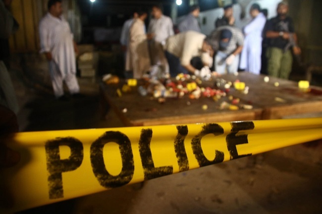 Pakistani police official inspect a scene after unknown assailants opened fire on the police officials while they breaking fast, in Karachi, Pakistan, 23 June 2017. (EPA-Yonhap)