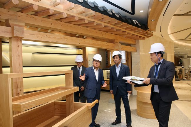 Executives at Lotte Duty Free including CEO Jang Sun-wook (second from left) on Thursday take a final look around the company’s World Tower branch before the grand opening. (Lotte Duty Free)