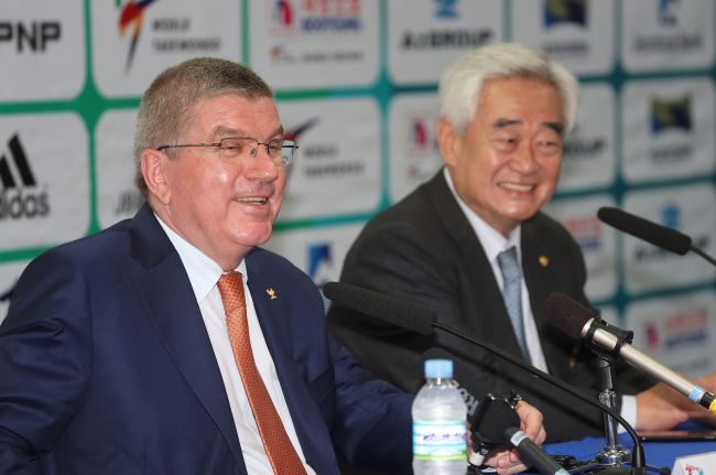 Thomas Bach (left), president of the International Olympic Committee, smiles alongside Choue Chung-won, head of the World Taekwondo Federation, at a press conference held during the WTF World Taekwondo Championships in T1 Arena in Muju, North Jeolla Province, on June 30, 2017. (Yonhap)