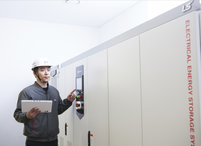 A LS Industrial Systems engineer checks on the power conditioning system that charges, supplies and converts power generated from a solar power system at the company’s Cheongju plant. (LSIS)