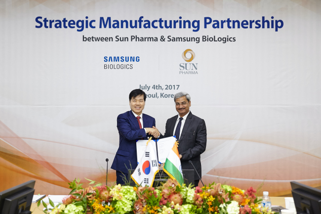 Samsung BioLogics CEO Kim Tae-han (left) and Sun Pharma CEO Anil Kumar Jain pose during a ceremony to mark their new manufacturing partnership held Tuesday at the Samsung BioLogics headquarters in Songo, Incheon. (Samsung BioLogics)