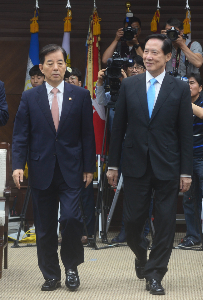 New Defense Minister Song Young-moo (right) and outgoing Minister Han Min-koo walk to their inauguration and farewell ceremony at the ministry headquarters in Seoul on Friday. (Yonhap)