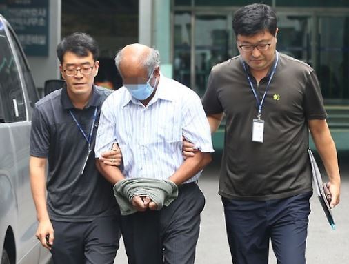 Officers take the Sri Lankan charged with robbing and raping a South Korean college student in 1998, to the Daegu High Court for an appeals trial on Aug. 11, 2015. (Yonhap)