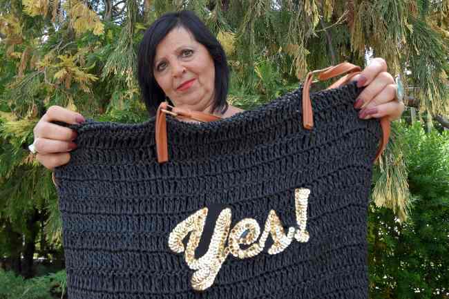 Spanish national Pilar Abel Martinez, 61, who claimed to Salvador Dali’s daughter, poses with a bag reading “Yes” during an interview in Barcelona on Monday. (AFP-Yonhap)