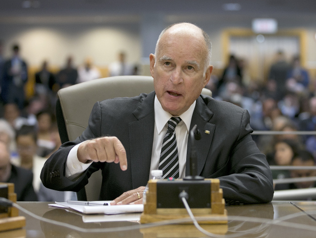 California Gov. Jerry Brown, left, responds to a question while testifying in support of Assembly Bill 398, by Assemblyman Eduardo Garcia, D-Coachella, one of two bills to extend state's cap and trade program, during a hearing of the Senate Environmental Quality committee, Thursday, July 13, 2017, in Sacramento, Calif. (AP Photo)