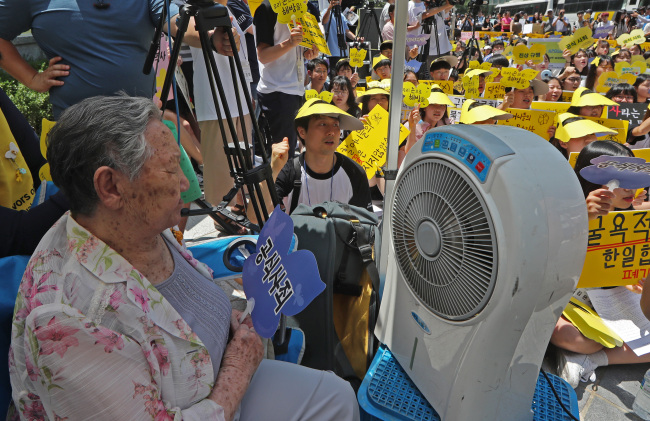 Former comfort woman Kil Won-ok (left) is seen during a protest against a 2015 settlement on Japan`s wartime sex slavery in front of the Japanese Embassy in downtown Seoul on Wednesday. (Yonhap)