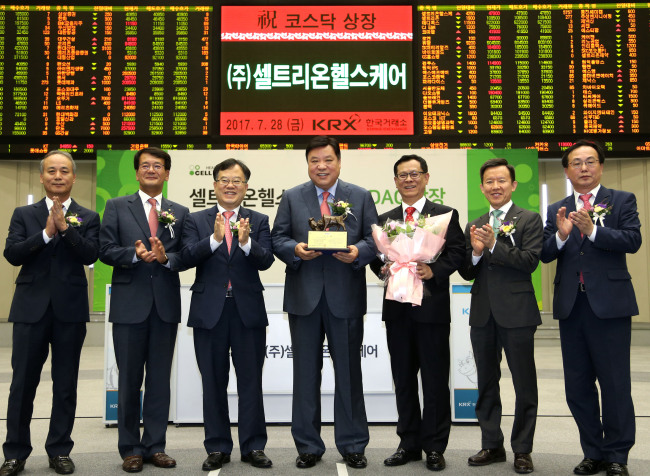 Celltrion President Kim Hyeong-gi (second from left), Celltrion founder Seo Jung-jin (center), Celltrion Healthcare Chief Executive Officer Kim Man-hoon (third from right) and officials from market operator Korea Exchange celebrate the initial public offering of Celltrion Healthcare on the second-tier Kosdaq market at the KRX headquarters in Seoul on Friday. (The Korea Exchange)