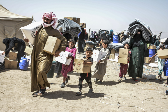 A displaced family at an IDP camp in Fallujah, Iraq receive food and relief items from ICRC. (The International Committee of the Red Cross)