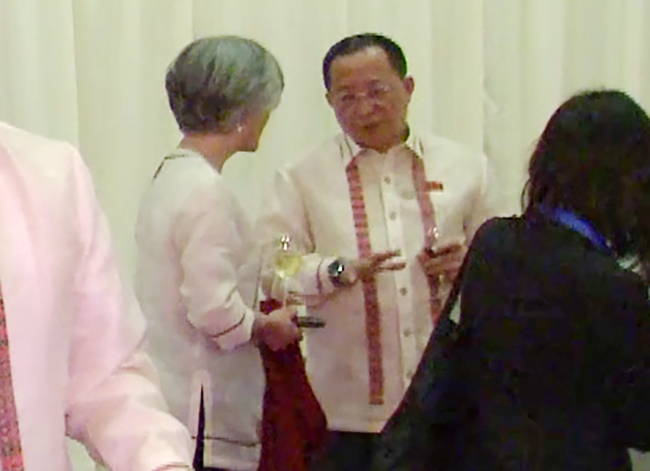 South Korean Foreign Minister Kang Kyung-wha (left) speaks with her North Korean counterpart Ri Yong-ho ahead of a gala dinner for top delegates of the ASEAN Regional Forum in Manila on Sunday. (Yonhap)