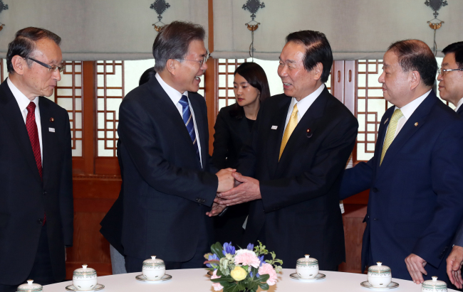 South Korean President Moon Jae-in (left) shakes hands with Fukushiro Nukaga, chairman of the Japan-Korea Parliamentarians' Union at Cheong Wa Dae on Monday. (Yonhap)