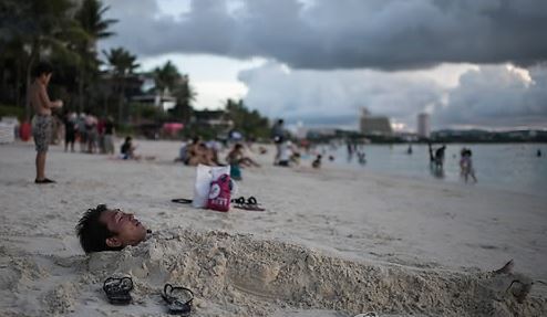 This AFP file photo shows a man lying on a beach in Guam. (Yonhap)