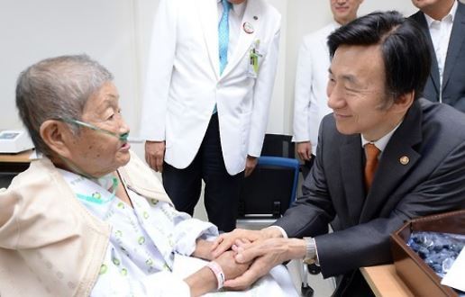 This photo, provided by the foreign ministry on Sept. 12, 2016, shows former Foreign Minister Yun Byung-se (R) visiting Ha Sang-sook, a South Korean victim of Japan`s wartime sexual slavery, at a hospital in Seoul. (Yonhap)