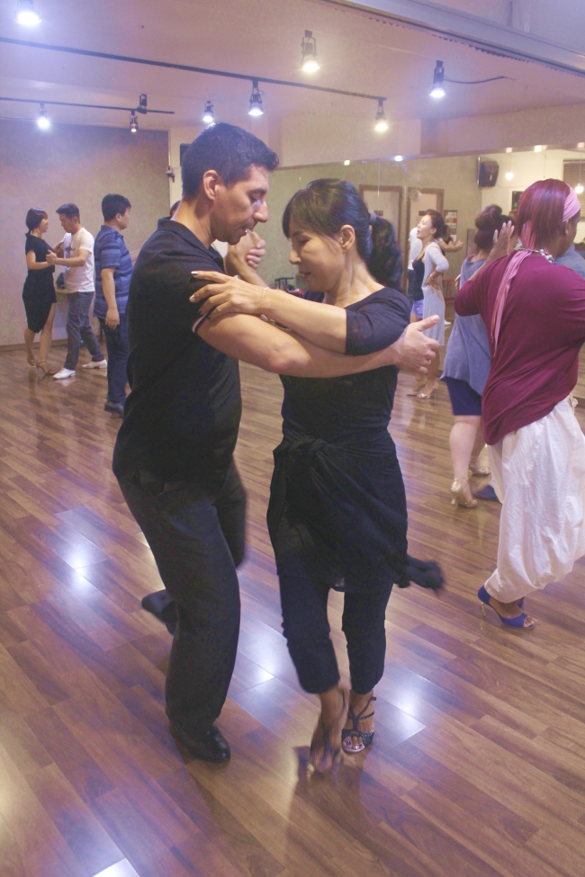 Tango instructor Emilio Andres Araya dances with a student during a tango lesson. (Anita McKay/The Korea Herald)