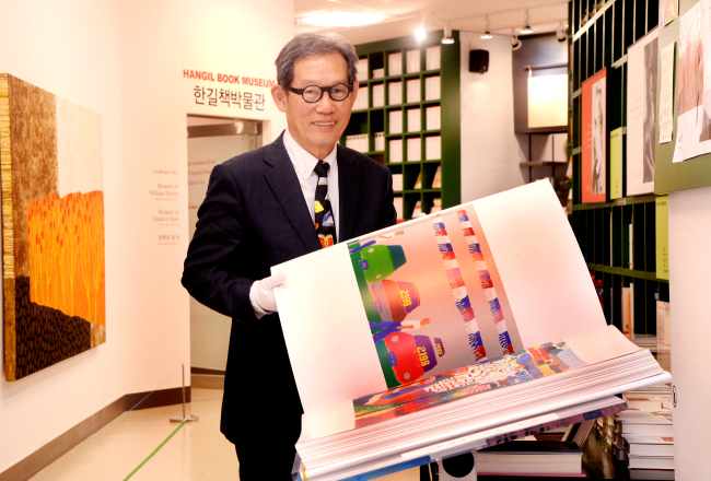 Hangilsa Publishing President Kim Eoun-ho holds a book at Sunhwadongchun in Sunhwa-dong, Seoul, on Sept. 8. (Park Hyun-koo/The Korea Herald)