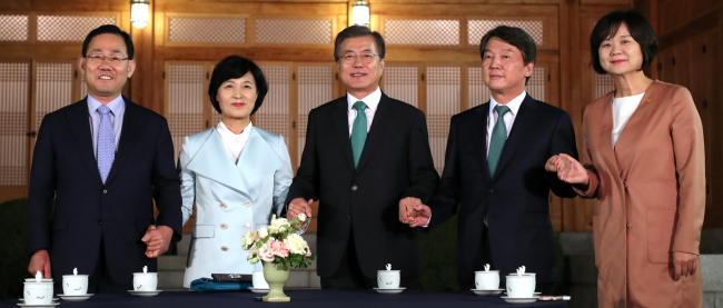President Moon Jae-in (center) holds hands with party leaders ahead of a dinner meeting on Wednesday. Pictured from left: Rep. Joo Ho-young of the conservative Bareun Party, Rep. Choo Mi-ae of the ruling Democratic Party, President Moon, Rep. Ahn Cheol-soo of the liberal People's Party and Rep. Lee Jeong-mi of the progressive Justice Party (Yonhap)