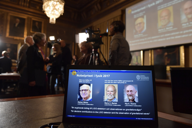The Royal Swedish Academy of Sciences, announces the 2017 Nobel Prize winners in Physics are pictured on a screen, with from left, Rainer Weiss, Barry C. Barrish and Kip S. Thorne, at the Royal Swedish Academy of Sciences in Stockholm, Sweden on Monday. (AP-Yonhap)