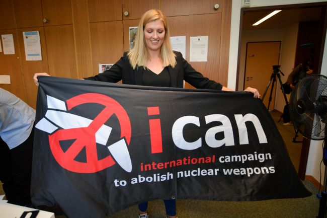 Nuclear disarmament group ICAN executive director Beatrice Fihn holds a banner with their logo after ICAN won the Nobel Peace Prize for its decade-long campaign to rid the world of the atomic bomb as nuclear-fuelled crises swirl over North Korea and Iran, on Oct. 6. (AFP-Yonhap)