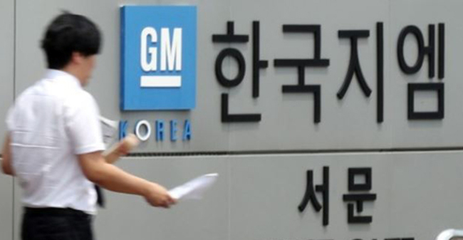 In this photo, taken July 6, 2017, a GM Korea worker passes by the west gate of the carmaker`s plant in Bupyeong, just west of Seoul. (Yonhap)