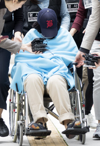 The daughter of the “Molar daddy,“ accused of assisting her father to dispose of the body of her friend, allegedly killed by her father, arrives at the Seoul Northern District Court on Thursday for a hearing on her arrest warrant. She remains hospitalized after overdosing on sleeping pills together with her father. (Yonhap)